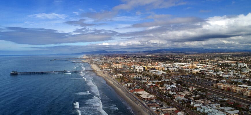 Beautiful dramatic drone panoramic aerial birds eye view Oceanside, California, Oceanside Pier Oceanside harbor and downtown plus miles of beach and dynamic cloudscape